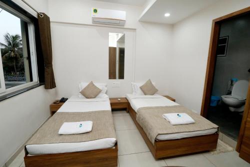 Postel nebo postele na pokoji v ubytování Nova Sahaj Residency