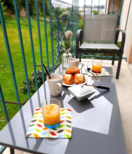 - une table avec un plateau de nourriture et de boissons dans l'établissement La Poterie - Appartement avec balcon et parking privé, à Quimper