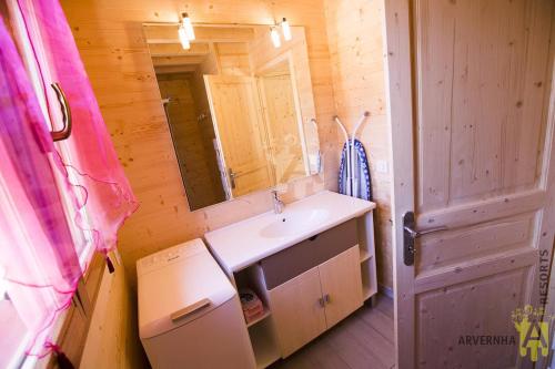 ein Badezimmer mit Waschbecken und Spiegel in der Unterkunft Chalet des Noisettes in Murol