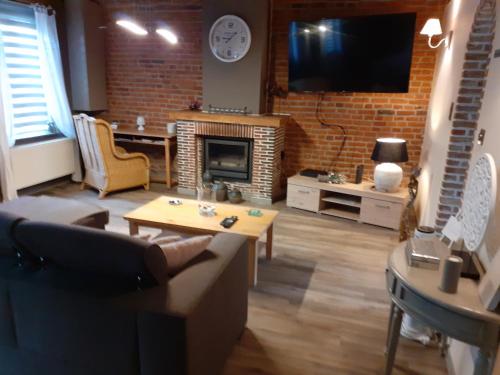 a living room with a couch and a fireplace at Le Charm'en Gîte in Tournai