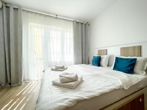 1 dormitorio con 1 cama blanca grande y toallas. en National Arena Studio, en Bucarest