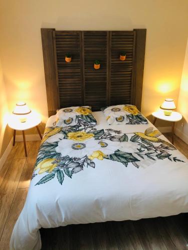 une chambre avec un lit avec un couvre-lit fleuri dans l'établissement Villa piscine privée vallée châteaux Dordogne, à Saint-Cybranet