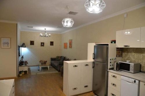 a kitchen and a living room with a refrigerator at BC Apartments in Tbilisi City