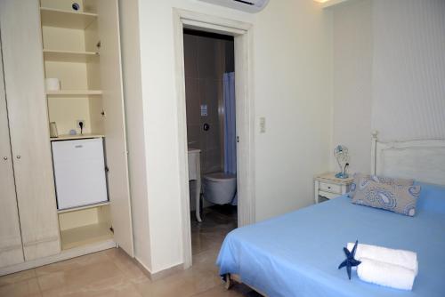 una camera con letto blu e un bagno di Villa Nostalgia Lentas No3 a Lentas