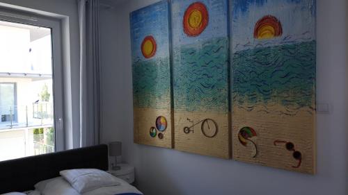 ein Gemälde, das an einer Wand in einem Schlafzimmer hängt in der Unterkunft Impresja 42 Apartament z garażem in Kołobrzeg