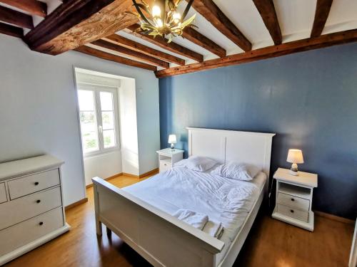 a bedroom with a white bed and a blue wall at Villa Gold Beach in Saint-Côme-de-Fresné