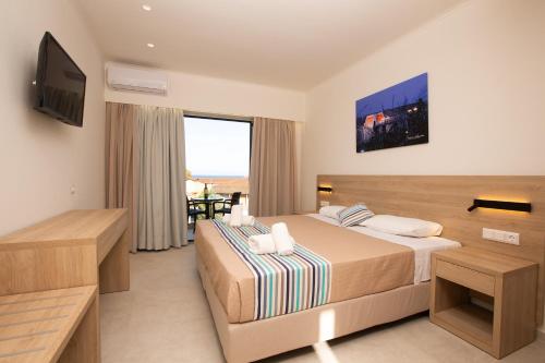a hotel room with a bed and a television at Passas Mare Apartments & Studios in Benitses