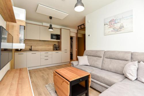 ein Wohnzimmer mit Sofa und Tisch in der Unterkunft Dianos apartamentai in Palanga