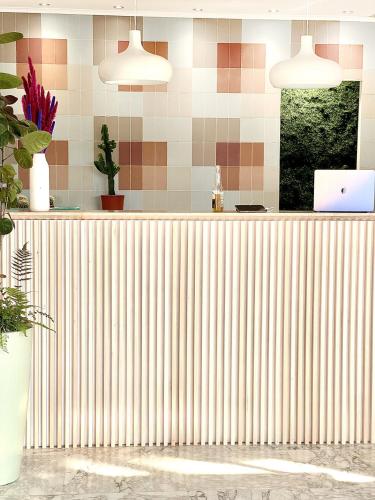a lobby with a counter with a laptop on it at Hotel Blumen in San Benedetto del Tronto