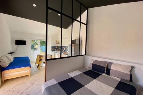 ein Schlafzimmer mit einem Bett und einem großen Fenster in der Unterkunft Studio avec une belle terrace Pour les amoureux in Carcès