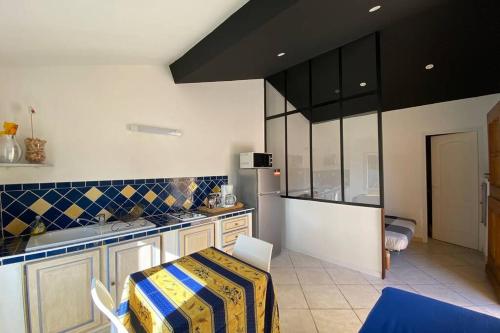 une cuisine avec une table et un comptoir dans l'établissement Studio avec une belle terrasse Pour les amoureux, à Carcès