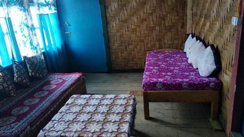 a small room with two beds and a bench at Vamoose Red Panda in Sombāri
