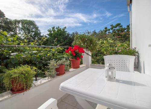 a white table and chair on a balcony with plants at Efi's apartment in Marathias