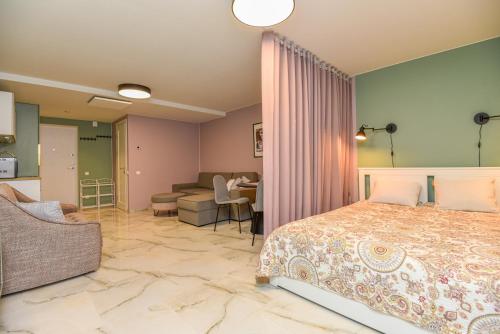 a bedroom with a bed and a living room at Neringos apartamentai in Palanga