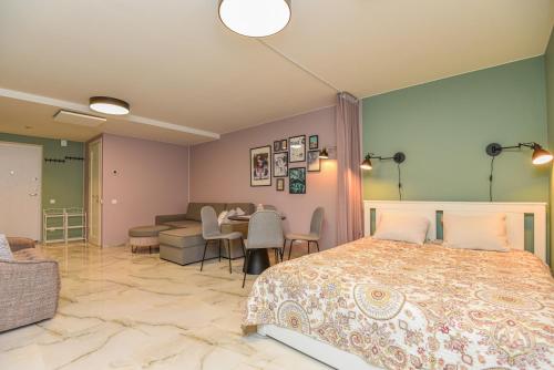 a bedroom with a bed and a table and a couch at Neringos apartamentai in Palanga