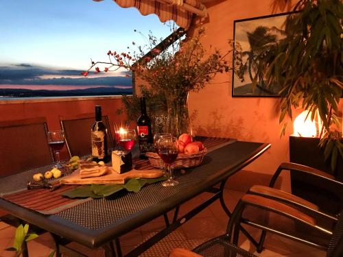 - une table avec un bol de fruits et des bouteilles de vin dans l'établissement ELYSION, à Crikvenica