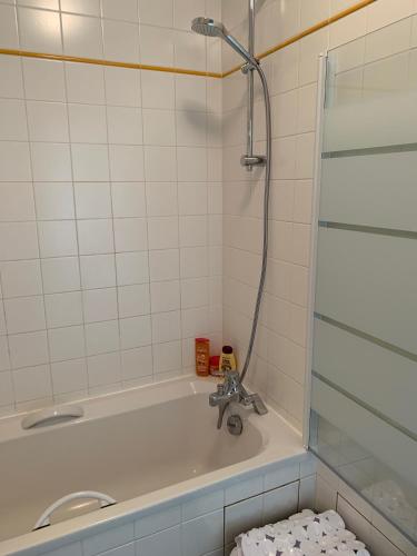 une salle de bain avec baignoire et douche dans l'établissement Appartement Wimereux - Opaalkust met frontaal zeezicht, à Wimereux