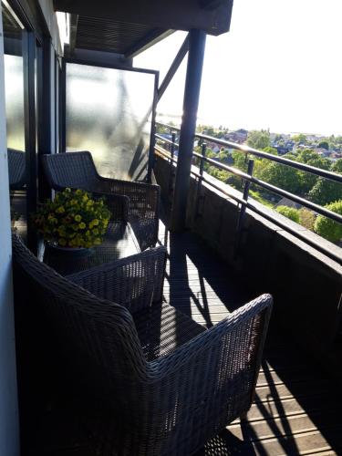 einen Balkon mit Korbstühlen und einer Obstschale in der Unterkunft Panorama Apartment in Haapsalu