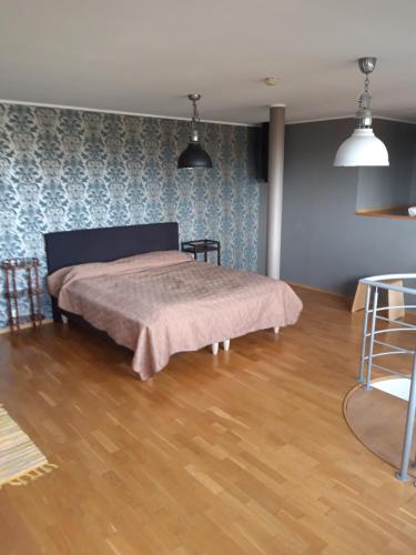 a bedroom with a bed and a wooden floor at Panorama Apartment in Haapsalu