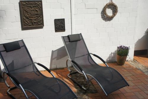 two black chairs sitting next to a wall at Designhotel 1690 & Apartments in Rendsburg