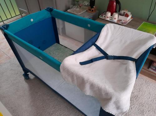 ein blaues Kinderbett mit einer weißen Decke in einem Zimmer in der Unterkunft La chambre Tomis Ath in Ath