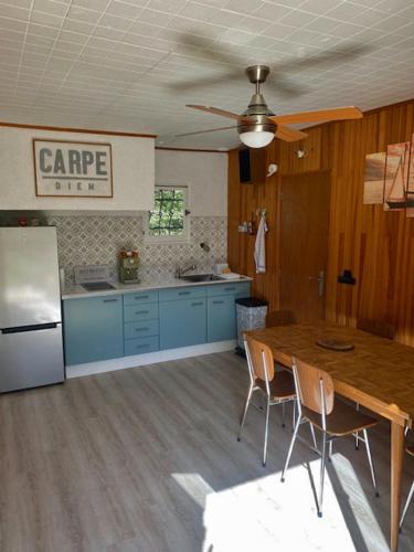 une cuisine avec une table en bois et un réfrigérateur dans l'établissement RIBES - Chalet Gîte au coeur de la nature, à Sournia