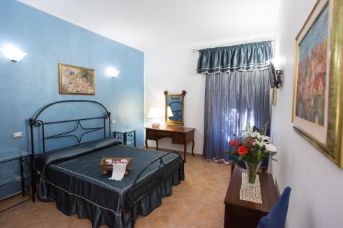 ein Schlafzimmer mit einem Bett und einem Tisch mit Blumen in der Unterkunft Casa Lollobrigida in Ciampino