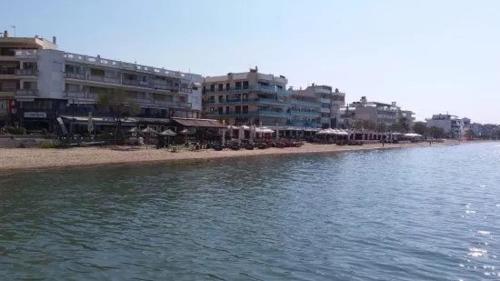 a beach with some buildings and a body of water at Q luxury rooms Perea center in Perea
