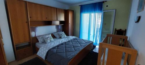 a small bedroom with a bed with blue curtains at Apartmani Premijer-Rab in Supetarska Draga