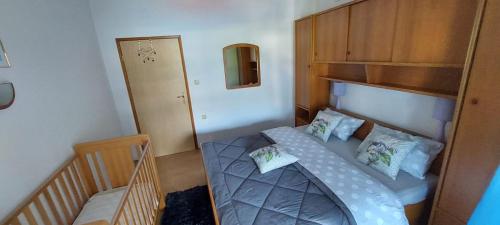 a small bedroom with a bed and a mirror at Apartmani Premijer-Rab in Supetarska Draga