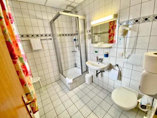 e bagno con servizi igienici, doccia e lavandino. di Amadeus Boutique Hotel Deutscher Hof a Georgenthal