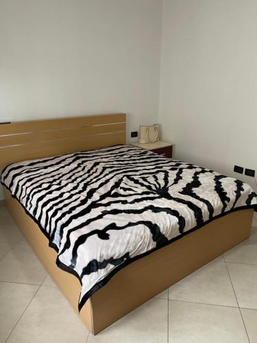uma cama num quarto com um cobertor de estampa de zebra em Super Apartment 100m2 2 sovrum em Shëngjin