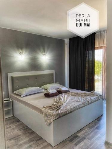 a large bed in a bedroom with a sign above it at Casa Perla Mării in 2 Mai
