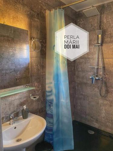 a bathroom with a shower curtain next to a sink at Casa Perla Mării in 2 Mai