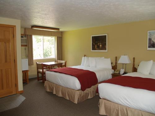 um quarto de hotel com duas camas e uma mesa em Wilson Lake Inn em Wilton