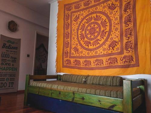 a couch against a wall with a large tapestry at Urban Yoga House Hostel & Retreat in Ioannina