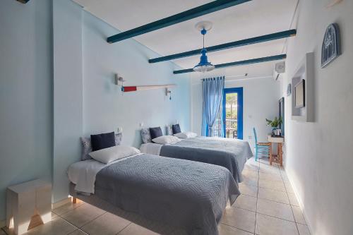 a room with two beds and a table with a chair at Atheras in Evdilos