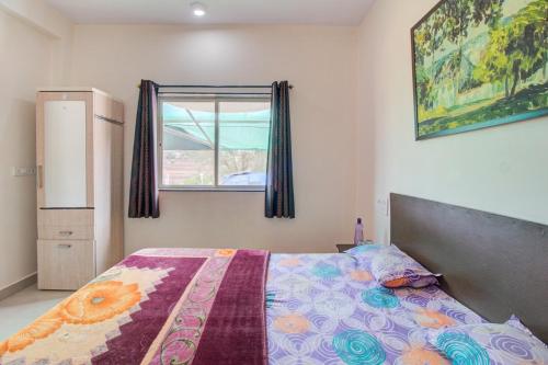 um quarto com uma cama e uma janela em Beautiful KP Sky View Bungalow em Mahabaleshwar