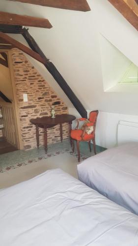 une chambre avec un lit, une table et une chaise dans l'établissement La Ferme de Sapharey, à Sarrazac
