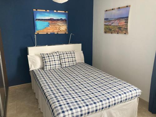 een kleine slaapkamer met een bed met een geruite deken bij Habitaciones tía Ela in Yaiza