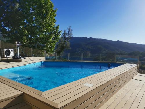 a large swimming pool with a wooden deck at CASA CAPUCINE in Rio Caldo