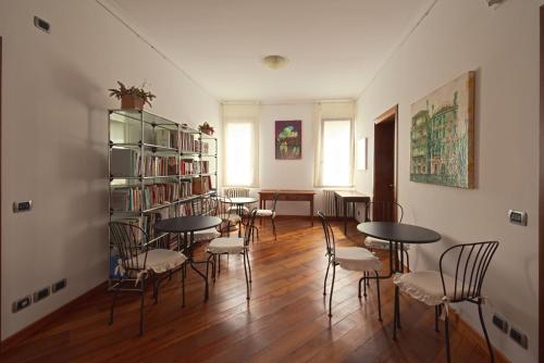 ein Zimmer mit Tischen und Stühlen und einem Bücherregal in der Unterkunft Corte dei Miracoli in Venedig