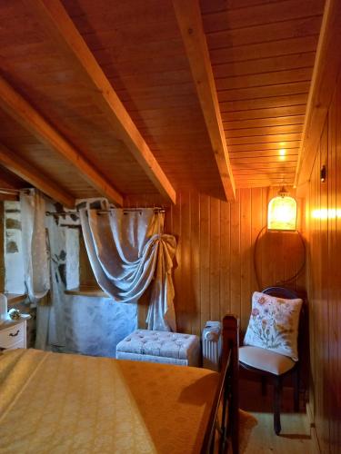um quarto com uma cama e uma cadeira num quarto em Talasnal Casas da Urze TER em Lousã