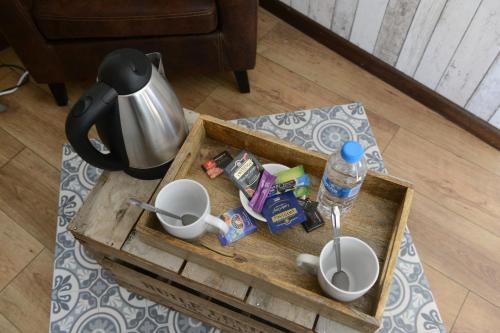 une table basse avec un plateau avec des tasses et une cafetière dans l'établissement Le Domaine du Pont Canon, à Plourivo