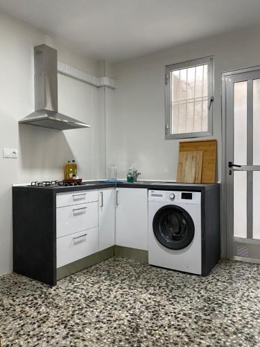 een keuken met een wasmachine en een fornuis bij Casa Quintero Valencia Playa Cabañal in Valencia