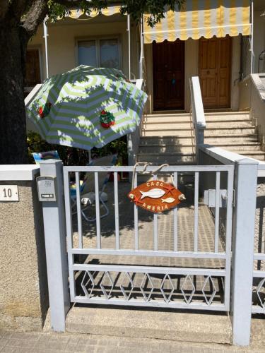 niebiesko-biały parasol siedzący na płocie w obiekcie Casa Ameria w mieście Cecina