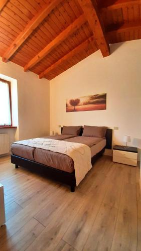 a bedroom with a large bed and a wooden floor at Rustico Casetta Pia in Malcesine
