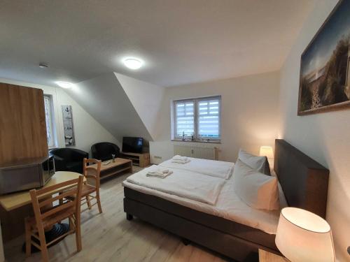 a bedroom with a bed and a table and a desk at Ferienwohnung Kranichnest in Neddesitz