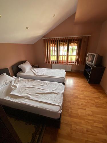 a bedroom with two twin beds and a television at CASA LEXIMAR in 2 Mai