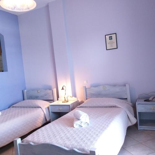 a room with two beds and a lamp on a table at 9 Muses in Agia Pelagia Kythira